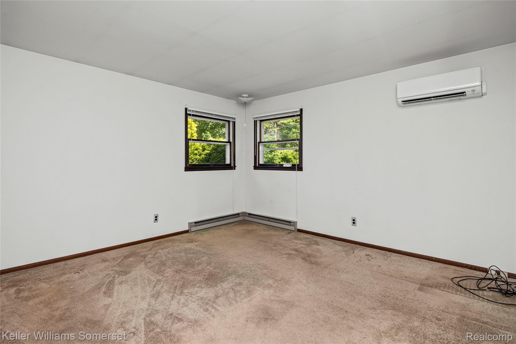 2344 Rochester Road Leonard, MI 48367 - Photo 27 of 66 Room featuring broadloom carpet, multiple windows, and a wall-mounted mini-split unit