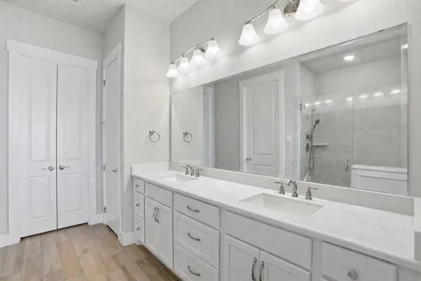 a bathroom with double vanity sinks and a mirror