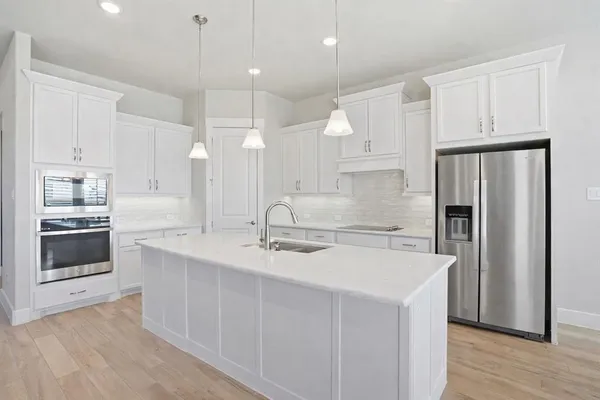 a kitchen with kitchen island a sink stainless steel appliances and cabinets