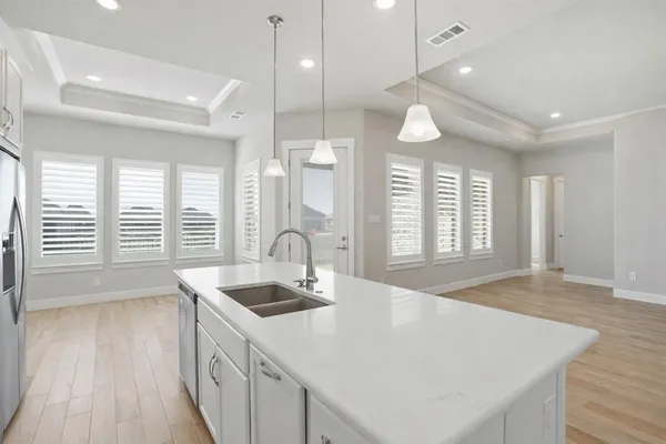 a kitchen with a sink a center island a wooden floor and a large window