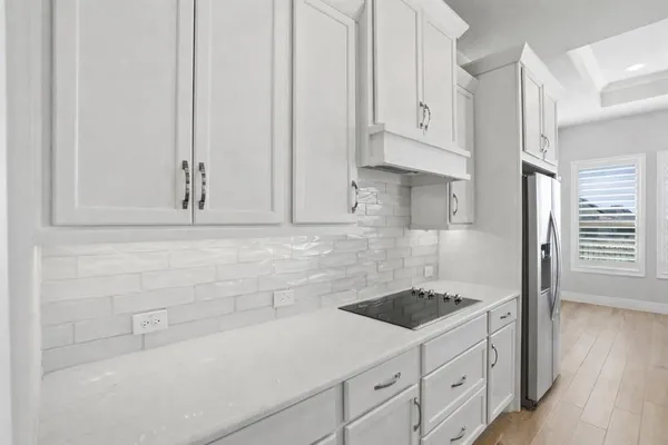 a kitchen with white cabinets and sink
