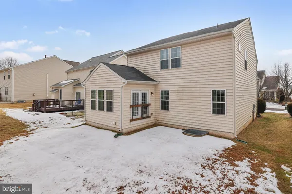 a front view of a house with a yard covered in snow