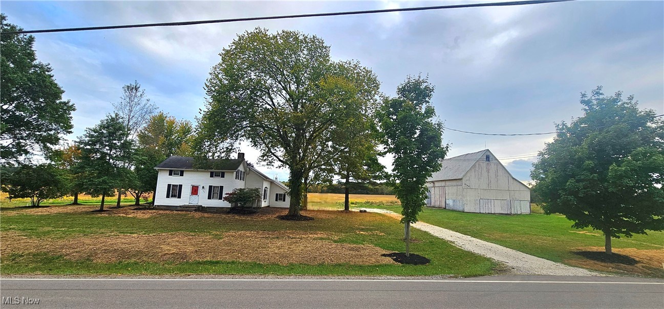 6162 Spieth Road Medina, OH 44256 - Photo 2 of 14 View of the front of the house surrounded by trees, it has a large yard, and the old barn with an equipment shed.