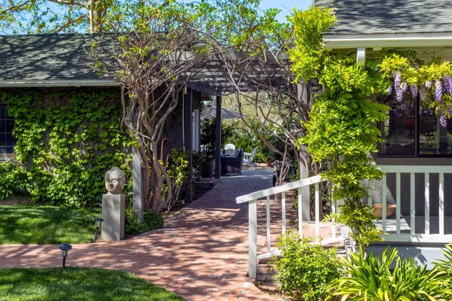 an aerial view of residential houses with outdoor space and trees