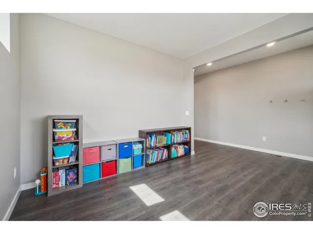 a living room with painting on the wall and a wooden floor