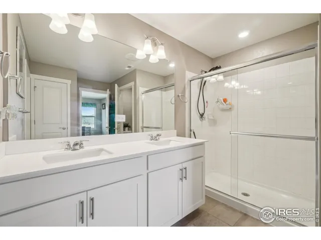 a bathroom with a double vanity sink mirror and shower