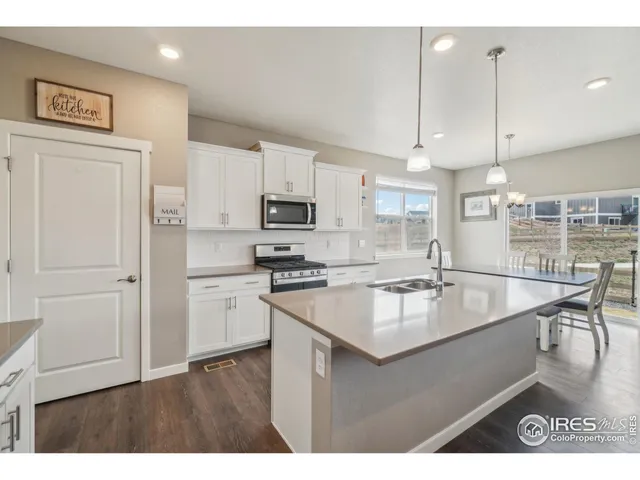 a kitchen with kitchen island a counter top space a sink stainless steel appliances and cabinets