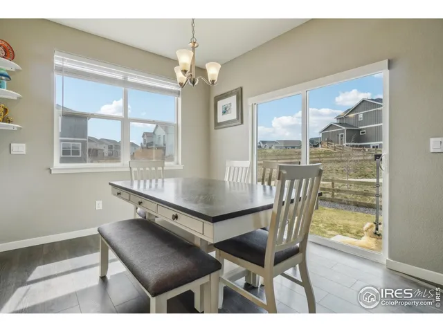 a dining room with furniture a chandelier and wooden floor