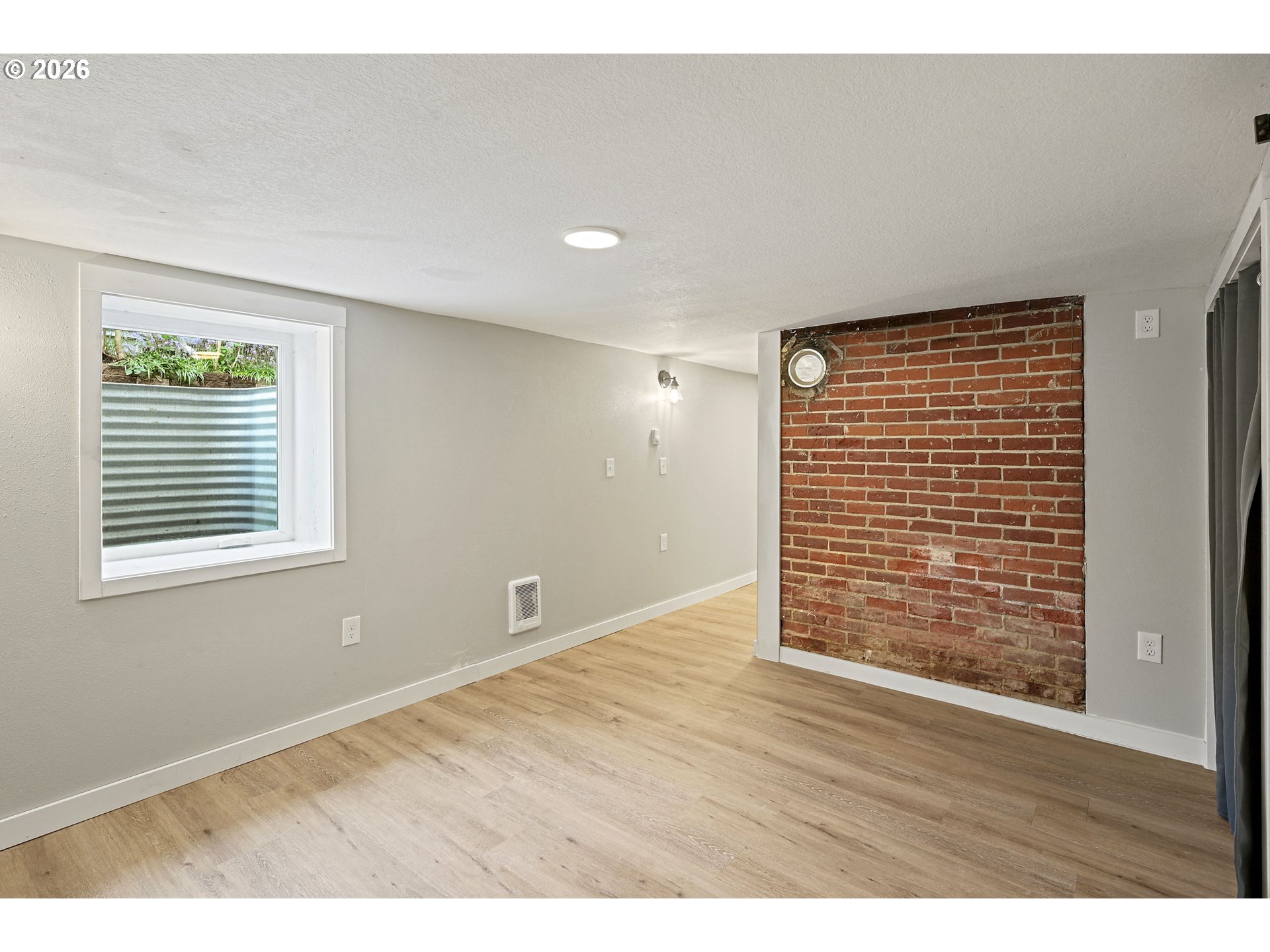 634 Northwest Ivy Street Camas, WA 98607 - Photo 20 of 27 a view of an empty room with wooden floor and a window