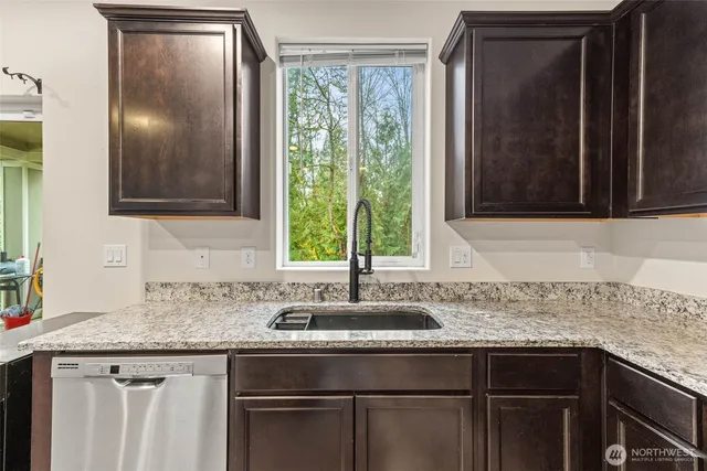 a kitchen with granite countertop a sink and cabinets