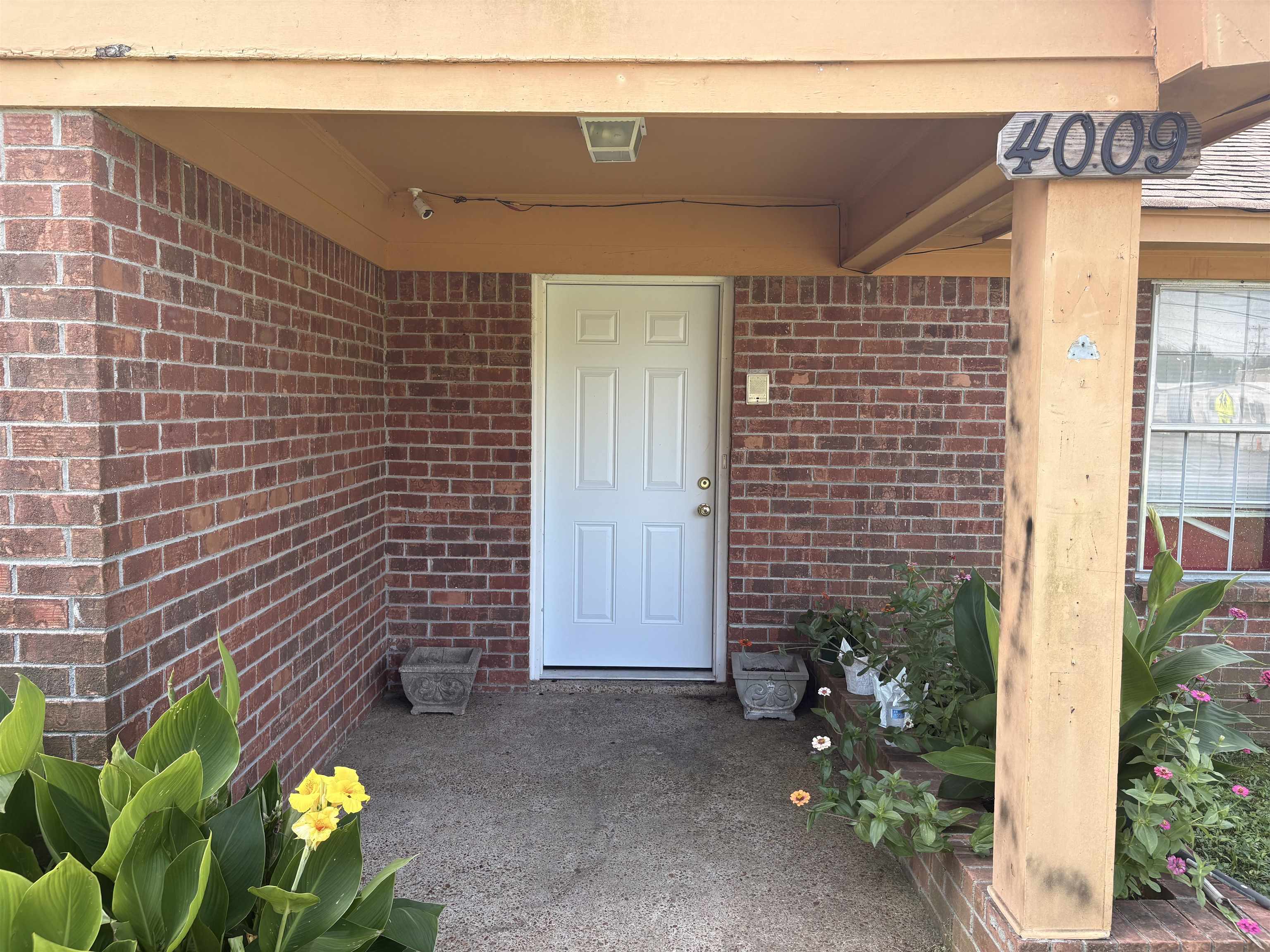 4009 Tessland Road Memphis, TN 38128 - Photo 4 of 16 Covered entryway featuring a white paneled door, brick facade, and concrete porch