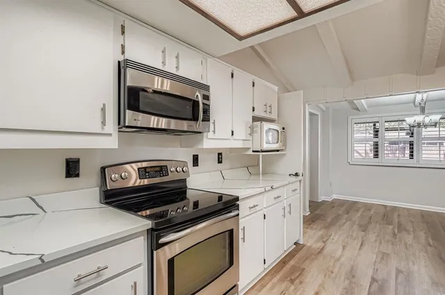 a kitchen with stainless steel appliances a stove microwave and sink