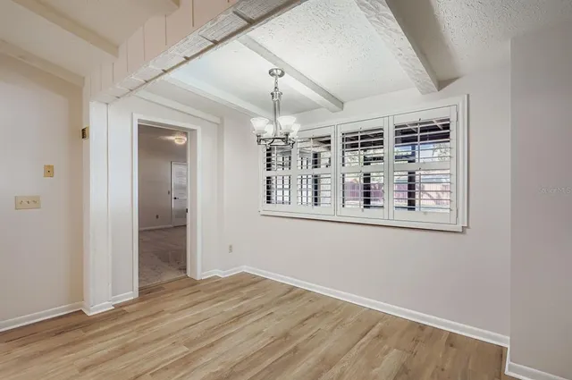 an empty room with wooden floor hallway and entryway