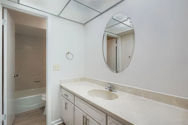 a bathroom with a granite countertop sink a mirror and a bathtub