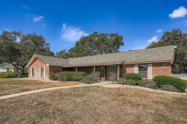 a front view of a house with a yard and potted plants