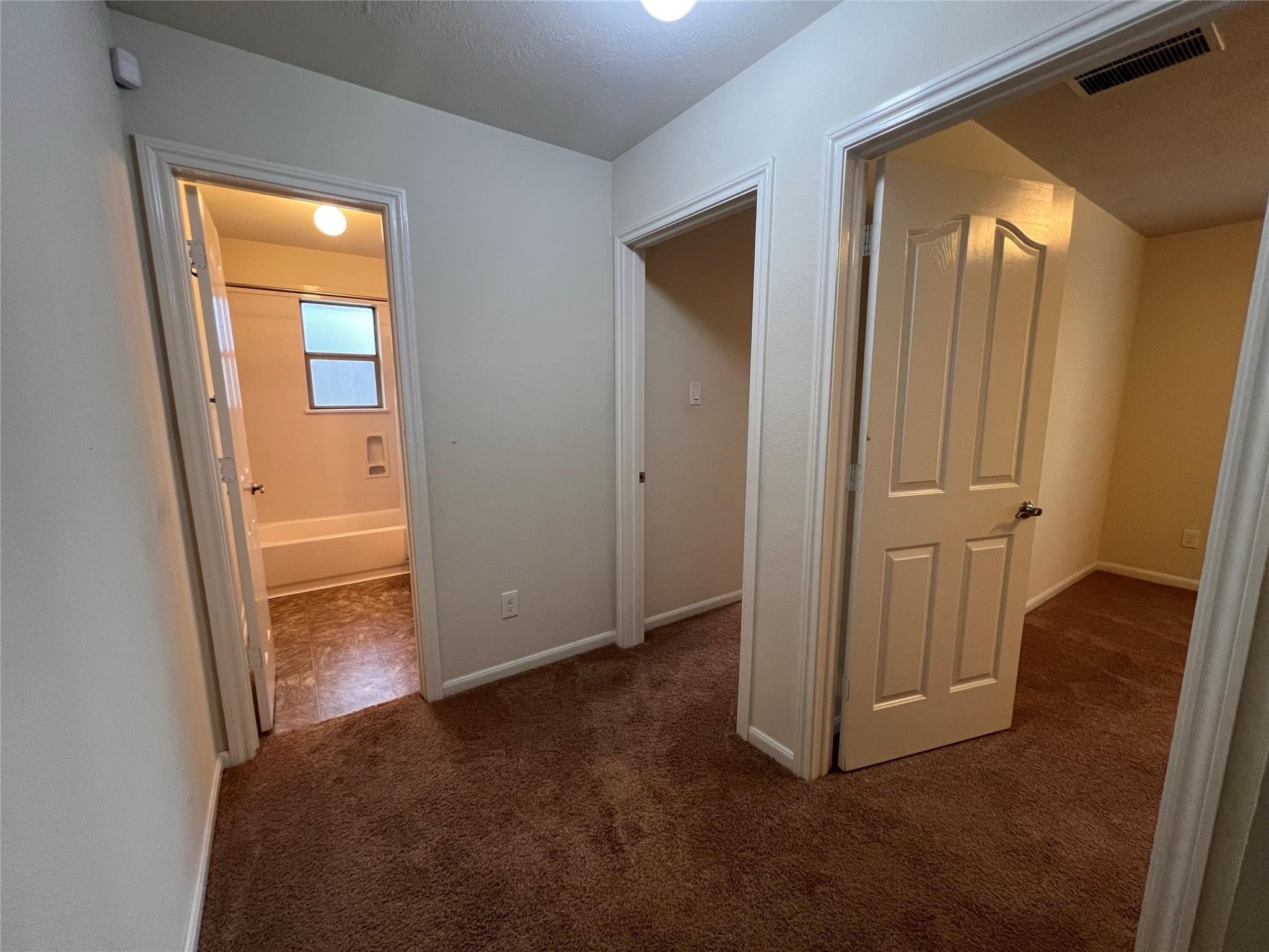 2502 Redrock Road League City, TX 77573 - Photo 11 of 19 The secondary bedrooms and bathroom are tucked away in their own private hallway, offering added privacy and a sense of separation from the main living areas.