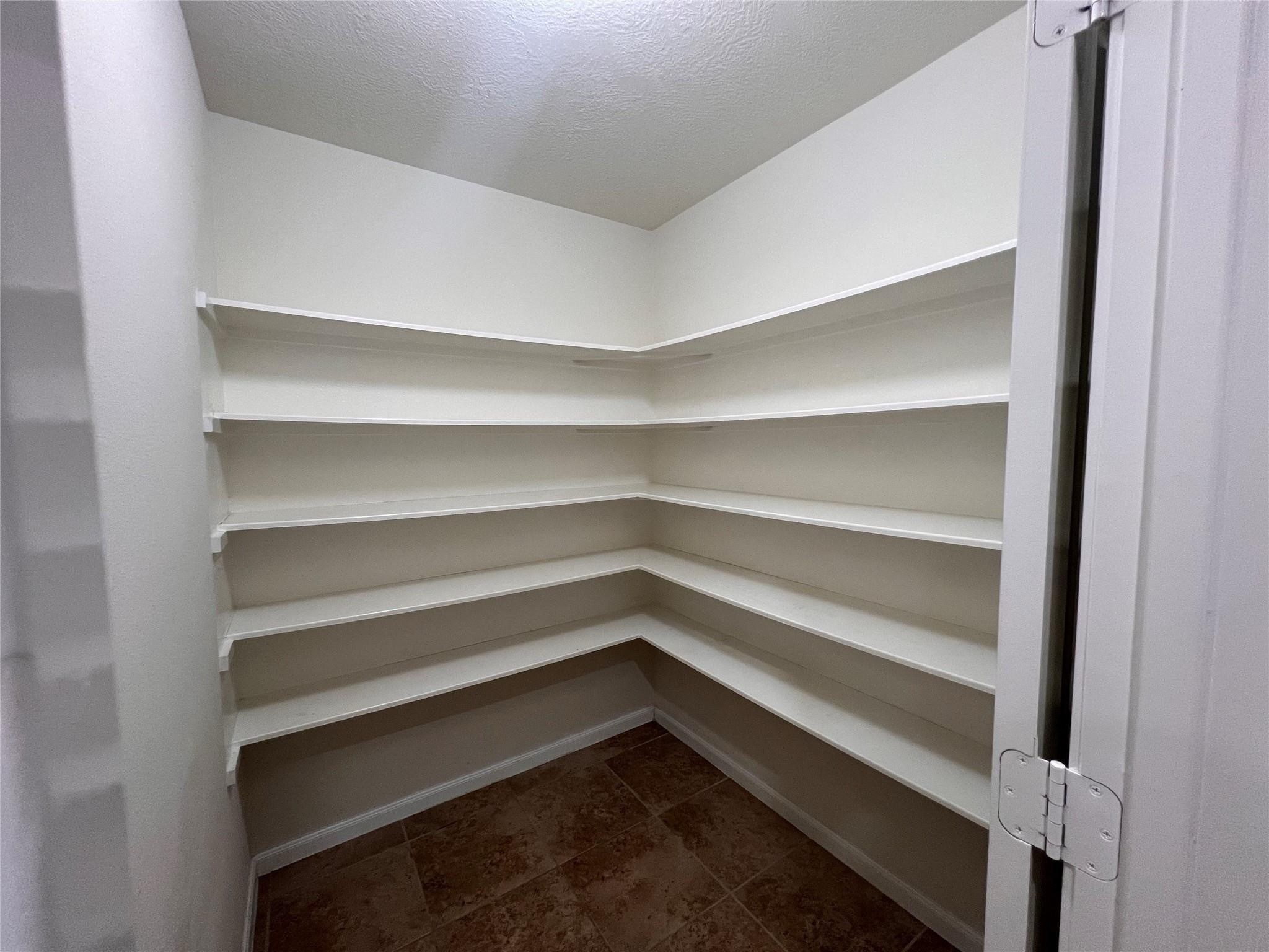 2502 Redrock Road League City, TX 77573 - Photo 5 of 19 This spacious corner pantry rivals the size of a walk-in closet, offering an impressive amount of storage for all your kitchen essentials.