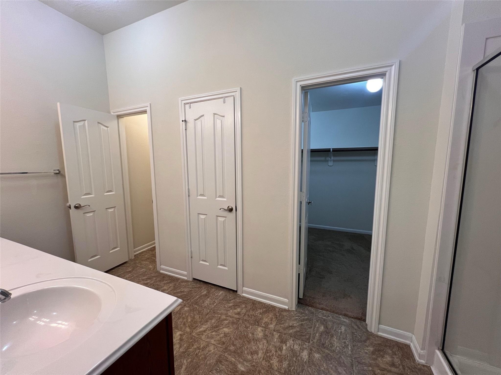 2502 Redrock Road League City, TX 77573 - Photo 8 of 19 The primary bathroom boasts an oversized walk-in closet, dual sinks with a stylish vanity, and a spacious walk-in shower.