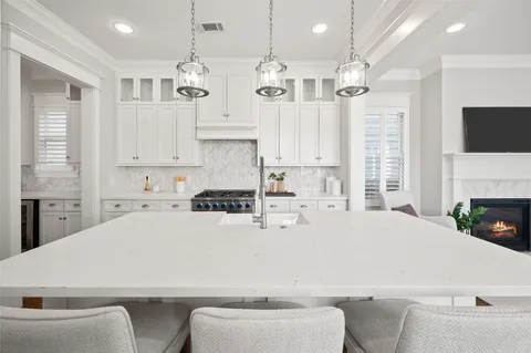a kitchen with stainless steel appliances granite countertop a stove a white cabinets and a wooden floors
