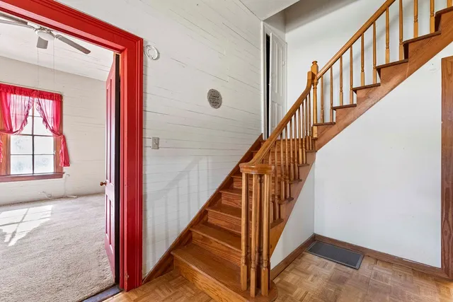 a view of staircase with wooden floor and a window