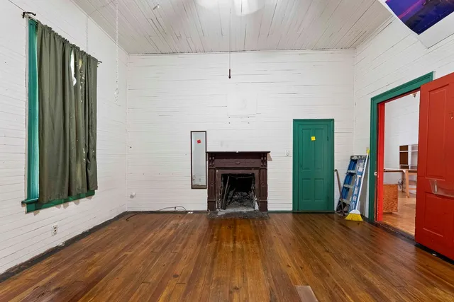 wooden floor fireplace and natural light in room