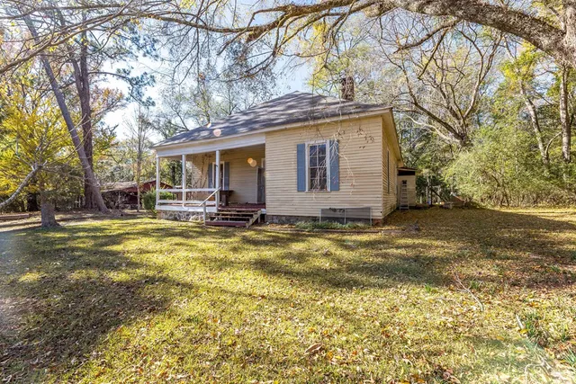 a view of a house with a yard and tree s