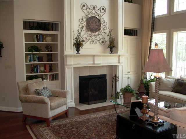 3915 Morvan Way Raleigh, NC 27612 - Photo 8 of 12 This 2 story family room feels open yet cozy. Large 3 tier mantle over the fireplace with built in media niche and bookcase. Good light streams in from the decorative wall of windows.