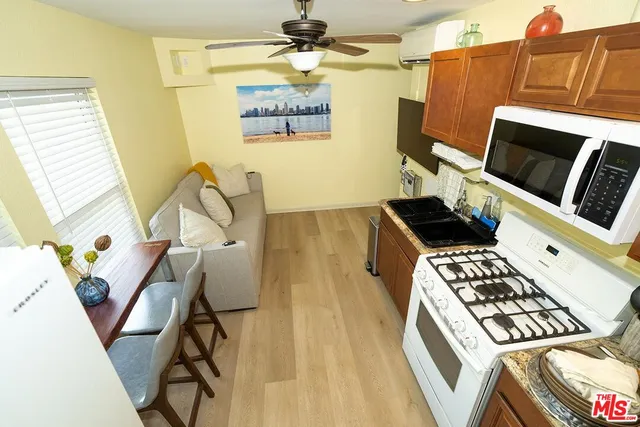 a kitchen with stainless steel appliances a stove a sink cabinets and a dining table