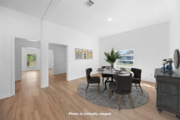 a dining room with wooden floor and a floor to ceiling window