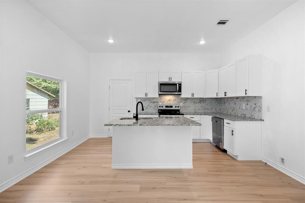 507 2nd Street Moody, TX 76557 - Photo 16 of 40 a large kitchen with a center island and stainless steel appliances