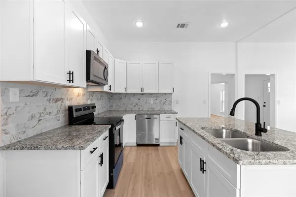 a kitchen with granite countertop a sink and cabinets