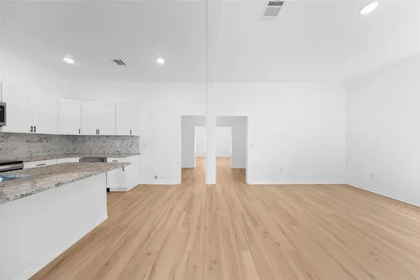 a view of a kitchen with wooden floor and a sink