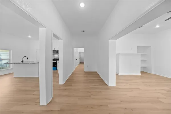 a view of a hallway with wooden floor and windows