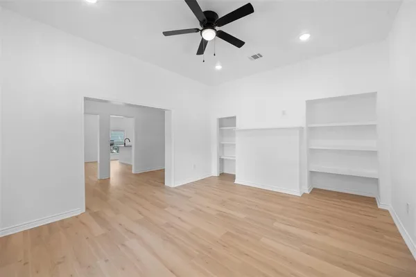 a view of empty room with wooden floor and window