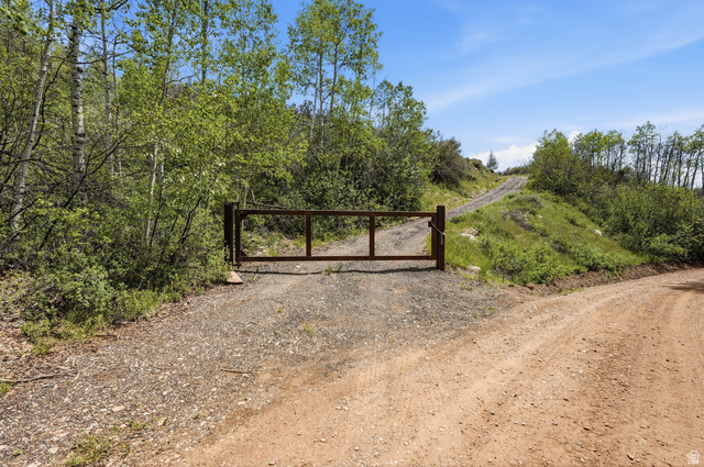 6 Beaver Springs Rancheros Oakley, UT 84055 - Photo 67 of 68 Gated entrance to a gravel drive, surrounded by mature trees and natural landscaping