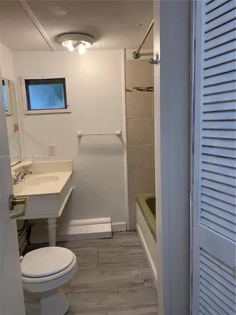 a bathroom with a sink a toilet a mirror and shower