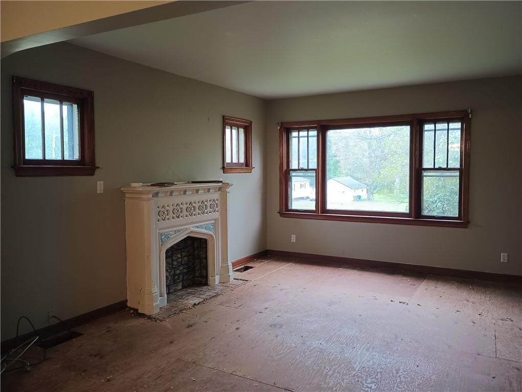 106 Conneaut Lake Road Greenville, PA 16125 - Photo 3 of 18 an empty room with fireplace and windows