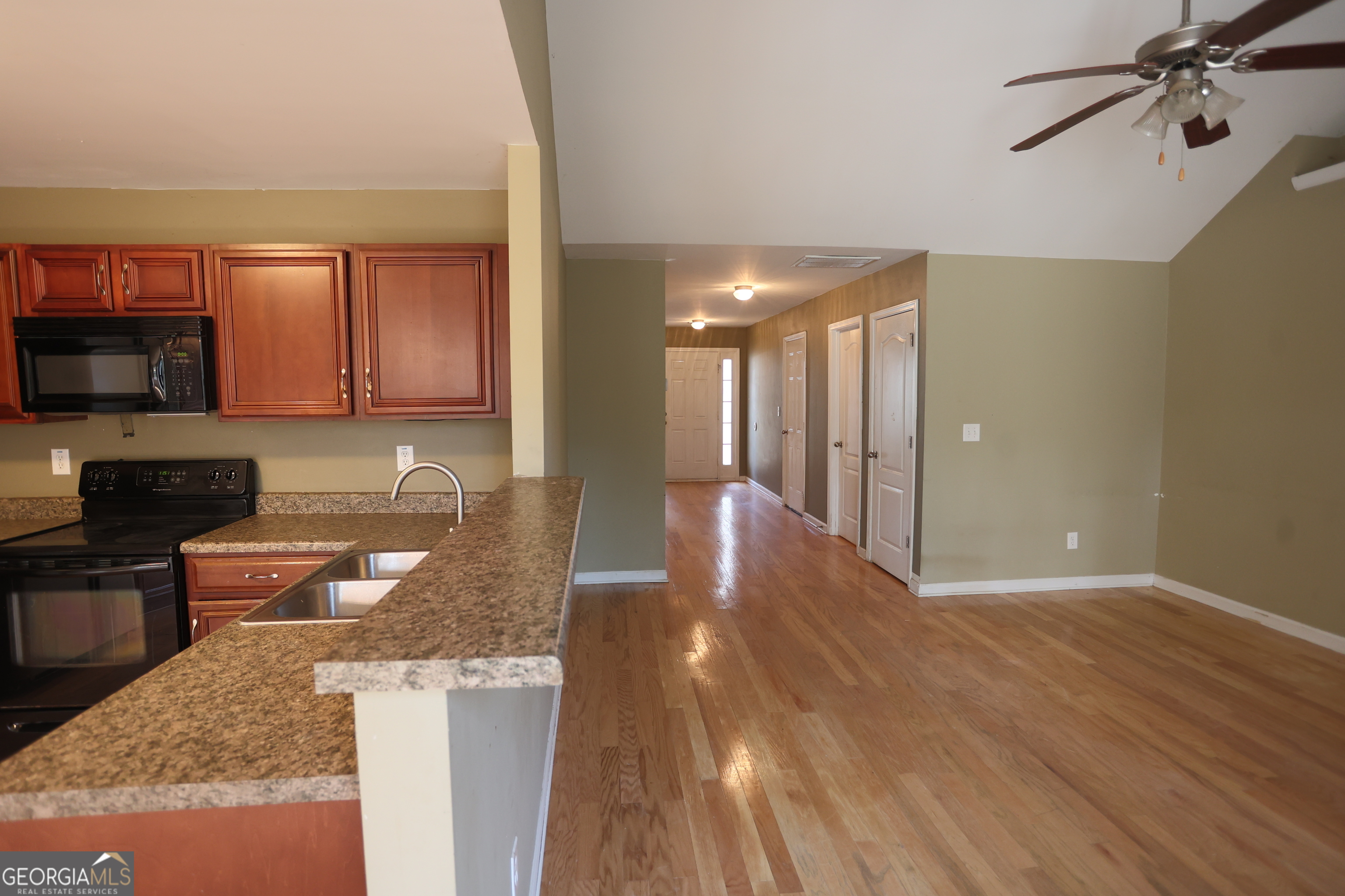 61 Concord Street North Concord, GA 30206 - Photo 25 of 37 a kitchen with granite countertop a stove and a wooden floors
