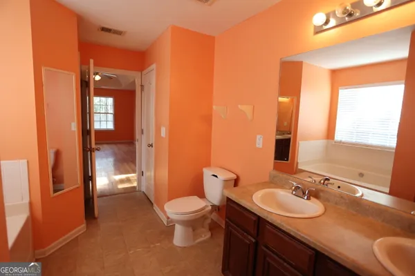 a bathroom with a toilet a sink and mirror