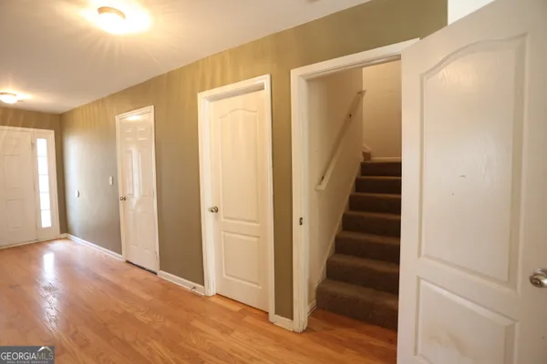 a view of a hallway with wooden floor and entryway