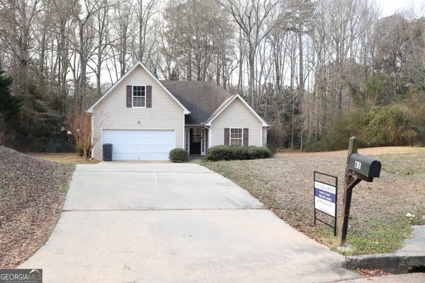 a view of a house with backyard and trees