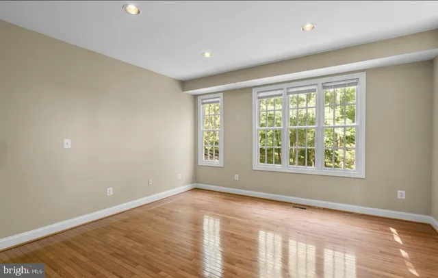 an empty room with a window and wooden floor