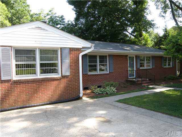 5121 Wickham Road Raleigh, NC 27606 - Photo 1 of 21 a front view of a house with a yard and a garage