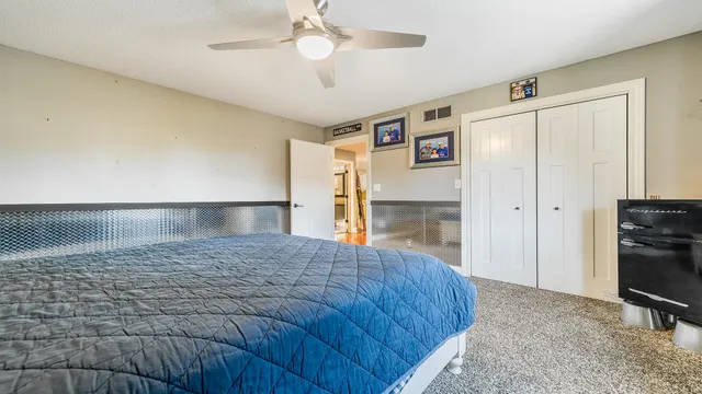 a spacious bedroom with a bed and a television