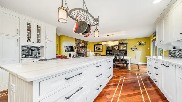 a large white kitchen with wooden floor