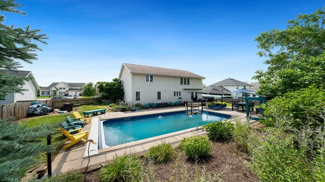 a view of a house with swimming pool and sitting area