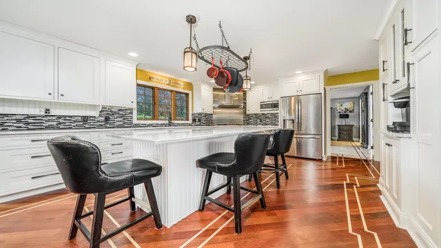 a kitchen with stainless steel appliances kitchen island granite countertop dining table chairs cabinets and a sink