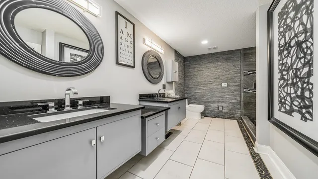 a bathroom with a granite countertop double vanity and a mirror