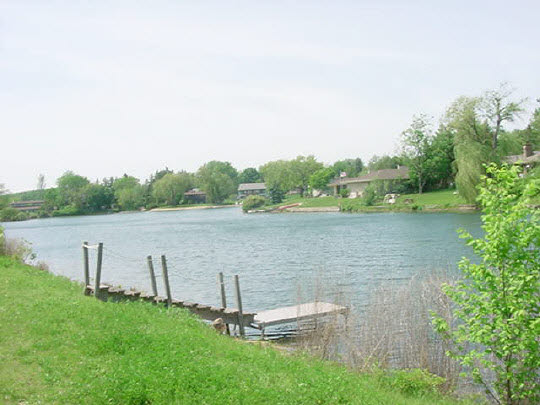 5728 Spring Brook Road Rockford, IL 61114 - Photo 6 of 6 a view of a lake with houses in the back