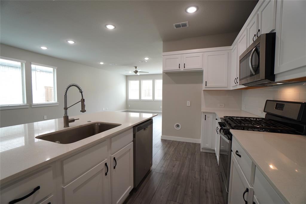 2512 Green River Road Royse City, TX 75189 - Photo 5 of 13 a kitchen with granite countertop a sink and wooden cabinets